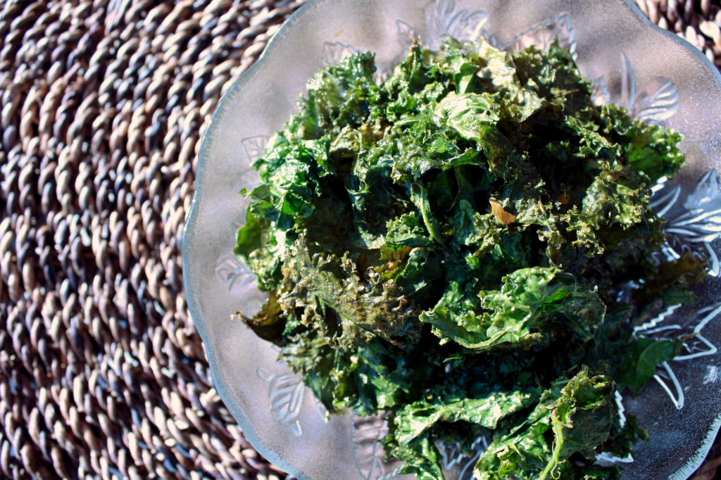 Overhead view of oven fresh kale chips, in a decorative class bowl