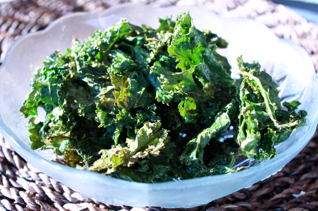 Bowl of crispy kale chips in a decorative glass bowl, sitting in the sunshine