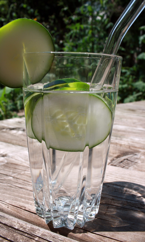 A nice tall glass of cucumber water, garnished with a cucumber slice, featuring my glass straw