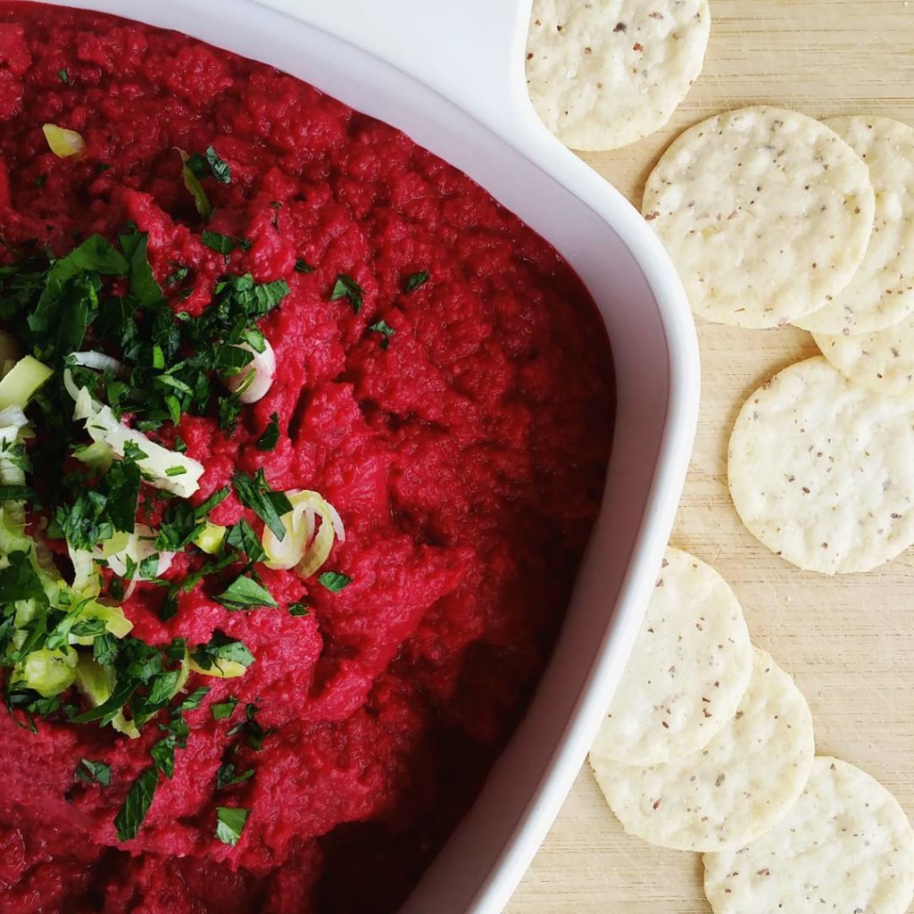 bowl of roasted beet hummus with a side of crackers